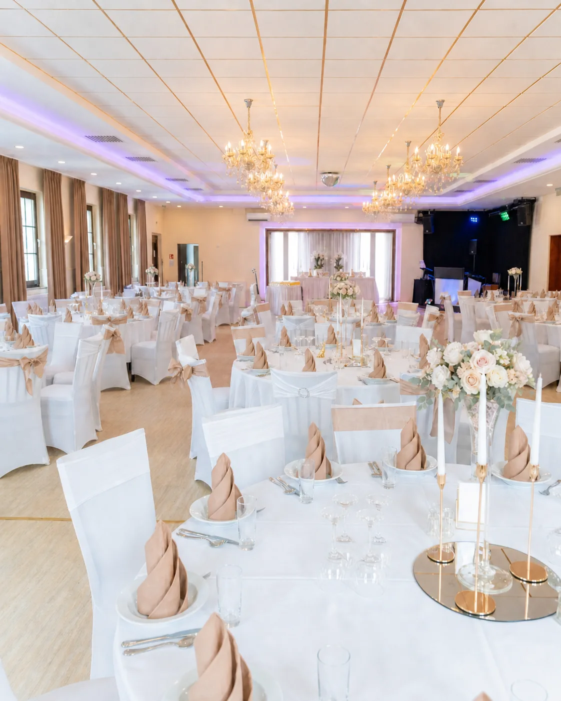 Festsaal mit eingedeckten Tischen, Kronleuchtern und Blumendekoration